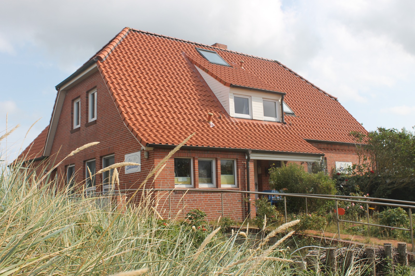 Haus Likedeeler, Seitenansicht mit Reetdach und Garten